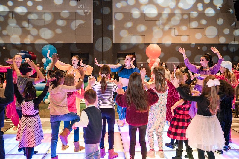 Kids and dancers on lit up disco floor