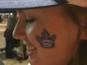 Woman with Maple Leafs logo on cheek