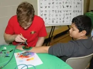 Man gives airbrush tattoo to boy