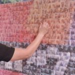 Man with mosaic wall