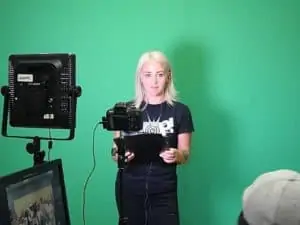 Host in front of green screen with camera and light