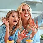 Daughter and mother with hands painted doing selfie