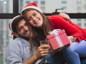 Holiday couple with gift box in condo