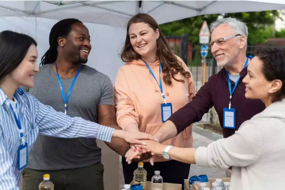 Employees place hands over hands